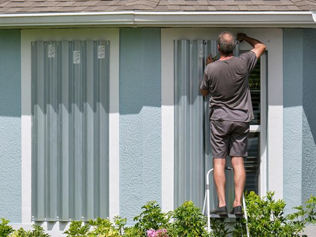 Person removing storm shudders after a storm